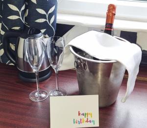 a table with two wine glasses and a happy birthday sign at The Gurkha Hotel in Blackpool