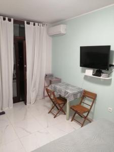 a room with a table and two chairs and a tv at Room and terrace in Krk