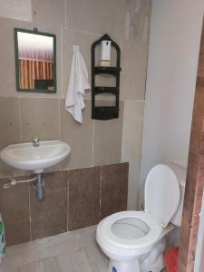 een badkamer met een wit toilet en een wastafel bij El Encanto Nature Reserve in Palestina