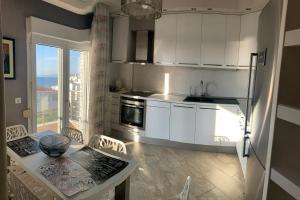 a kitchen with white cabinets and a table with chairs at Pearl House Skg in Neoi Epivates