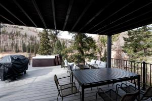 eine Holzterrasse mit einem Tisch und Stühlen darauf in der Unterkunft 49330 Highway 550 in Durango Mountain Resort