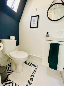 een badkamer met een toilet, een wastafel en een spiegel bij Apartment Direct Views of Eiffel Tower & Sacré-Coeur from Mezzanine - 10 mins to Paris Center in Parijs