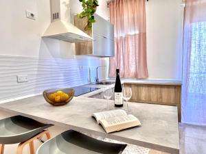 - une cuisine avec une table, une bouteille de vin et un livre dans l'établissement Villa di Nera Apartments, à Palerme