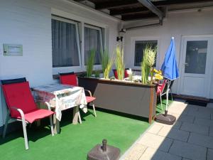 eine Terrasse mit einem Tisch und Stühlen auf einer grünen Etage in der Unterkunft Strandnest Büsum Apartments in Büsum