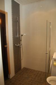 a bathroom with a shower with a glass door at Ristijärven Pirtti Cottage Village in Ristijärvi +87 photos