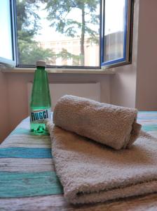 Fiuggiamo House في فيوجي: زجاجة مياه معدنية خضراء موضوعة فوق السرير