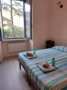 a bedroom with two beds with towels and a window at Fiuggiamo House in Fiuggi