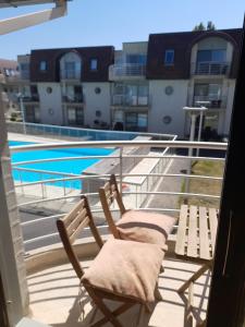 um par de cadeiras numa varanda com piscina em appartement zee zon en zwem em Bredene-aan-Zee
