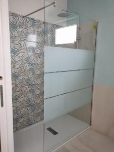 ducha con puerta de cristal y pared en La Suite della casa bianca, en San Salvatore Telesino
