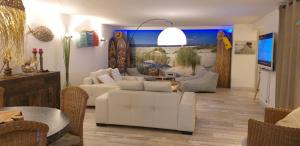 uma sala de estar com sofás brancos e uma mesa em Pomme de Pin et Mimosa em Grand-Village-Plage