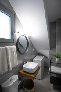 a bathroom with a white toilet and a mirror at Amarynthos Maisonettes in Amarynthos +44 photos