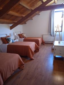 a room with three beds and a window at Albergue de peregrinos Santa Marina in Molinaseca