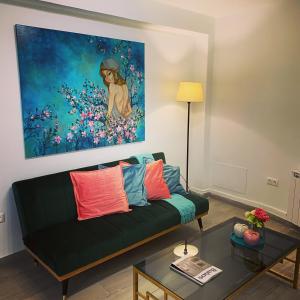 una sala de estar con sofá y una pintura en la pared en Apartamentos La Estación M&S, en Albacete
