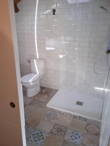 a white bathroom with a toilet and a shower at Albergue de peregrinos Santa Marina in Molinaseca