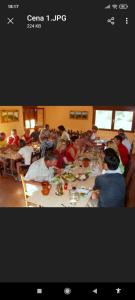 grupa ludzi siedzących przy długim stole w obiekcie Albergue de peregrinos Santa Marina w mieście Molinaseca