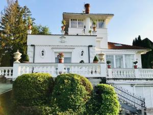 a white house with bushes in front of it at 3 Bedroom Private floor in Luxury Mansion in Budapest