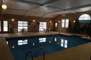 a large swimming pool in a room with a house at Gray Wolf Lodge in Manistique