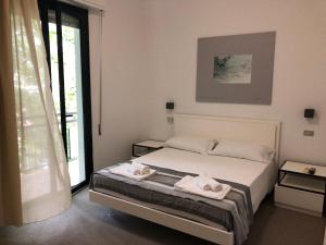 een slaapkamer met een bed met twee handdoeken erop bij Vinsea Hotel in Bellaria-Igea Marina