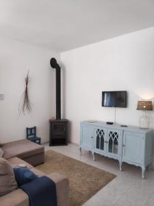 uma sala de estar com um sofá, uma televisão e uma lareira em Nature et al House - Casa para uso exclusivo com jardim em Batalha