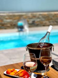 Korissia的住宿－Kea Paradise，桌子上放有一瓶葡萄酒和两杯酒