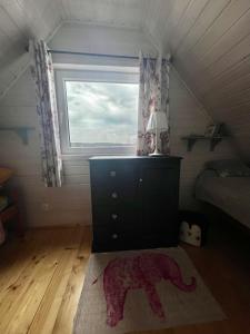 - une chambre avec un lit, une commode et une fenêtre dans l'établissement Domek Anuszka, à Sztutowo