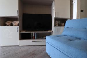 un soggiorno con divano blu e TV di Una Conchiglia sul Mare Attico vista Portofino a Zoagli
