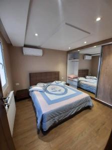 1 dormitorio con 1 cama grande y espejo en NEAPOLIS STUDIO, en Nabeul