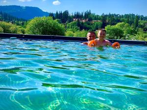 um homem e um rapaz a nadar numa piscina em Сонячні Карпати2 em Slavske