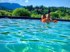 a man and a boy swimming in a swimming pool at На Двоїх in Slavske