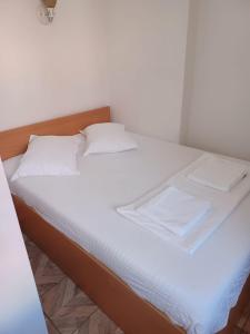 Una cama blanca con sábanas blancas y almohadas. en Bizet Studios, en Cluj-Napoca