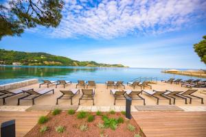 a group of chairs sitting next to a body of water at DINO apartma studio in soba - DINO Apartment Studio and Room in Portorož