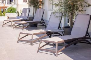 a row of chairs and tables on a patio at Vertmont Villa in Sveti Stefan