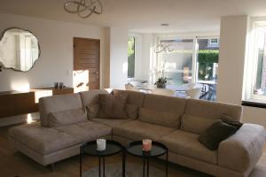 sala de estar con sofá y 2 mesas en Ashley’s Villa, en Blankenberge