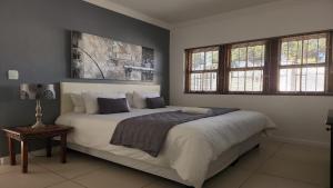 a bedroom with a large white bed with windows at Avanti Guest Lodge in Vredenburg +60 photos
