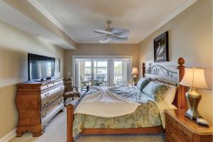 - une chambre avec un lit, une télévision et une commode dans l'établissement 403 Main Sail, à Île de Hilton-Head