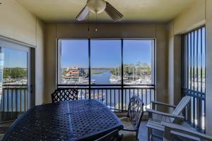 balcón con mesa y sillas y vistas al puerto en 403 Main Sail, en Hilton Head Island
