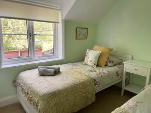 Willow Cottage on the upper River Bure في إيلشام: غرفة نوم صغيرة بها سرير ونافذة