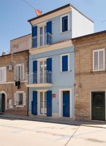 ein Gebäude mit blauen Türen auf einer Straße in der Unterkunft Camere Casa Azzurra in Porto San Giorgio