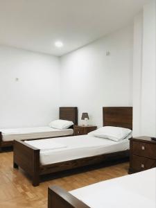 two beds in a room with white walls at Hostel le Coin d'Or in Fort de lʼEau