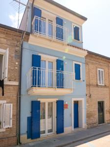 ein blaues Haus mit blauen Fensterläden an einem Gebäude in der Unterkunft Camere Casa Azzurra in Porto San Giorgio