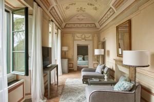 a living room filled with furniture and a large window at COMO Castello Del Nero in Tavarnelle Val di Pesa