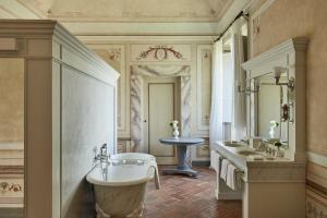 a bathroom with a sink and a bathtub at COMO Castello Del Nero in Tavarnelle Val di Pesa