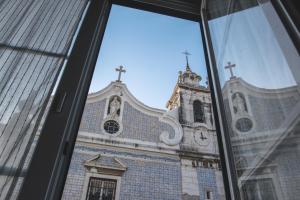 Una ventana con vistas a una iglesia. en Legendary Bay Suite Temática, en Seixal