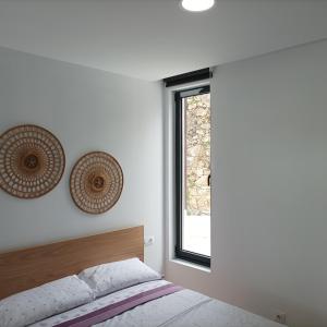 a bedroom with a bed and a window at Casiña de Cris in Boiro