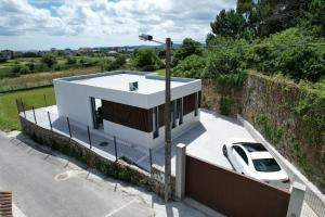 a white car parked in front of a house at Casiña de Cris in Boiro +2 photos
