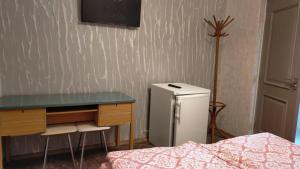 ein Schlafzimmer mit einem Schreibtisch und einem kleinen Kühlschrank in der Unterkunft Casa Irimescu in Gura Humorului
