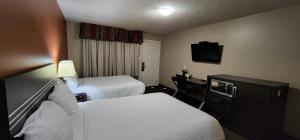 a hotel room with two beds and a television at Royal Lodge in Edmonton