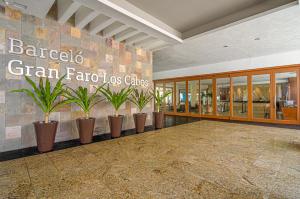 um átrio de um edifício com vasos de plantas em Barceló Gran Faro Los Cabos em San José del Cabo