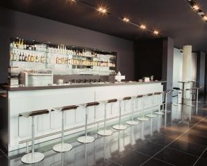 a row of stools at a bar in a restaurant at Kult Hotel in Ingolstadt