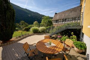 een patio met een tafel en stoelen en een balkon bij Villa Moselle in Traben-Trarbach